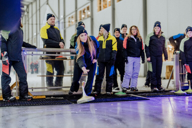 Bild zeigt Geschäftsführerin Winny Van der Valk beim Eisstockschießen im alpincenter in Hamburg-Wittenburg im Rahmen eines Teambuilding-Events auf der Skipiste