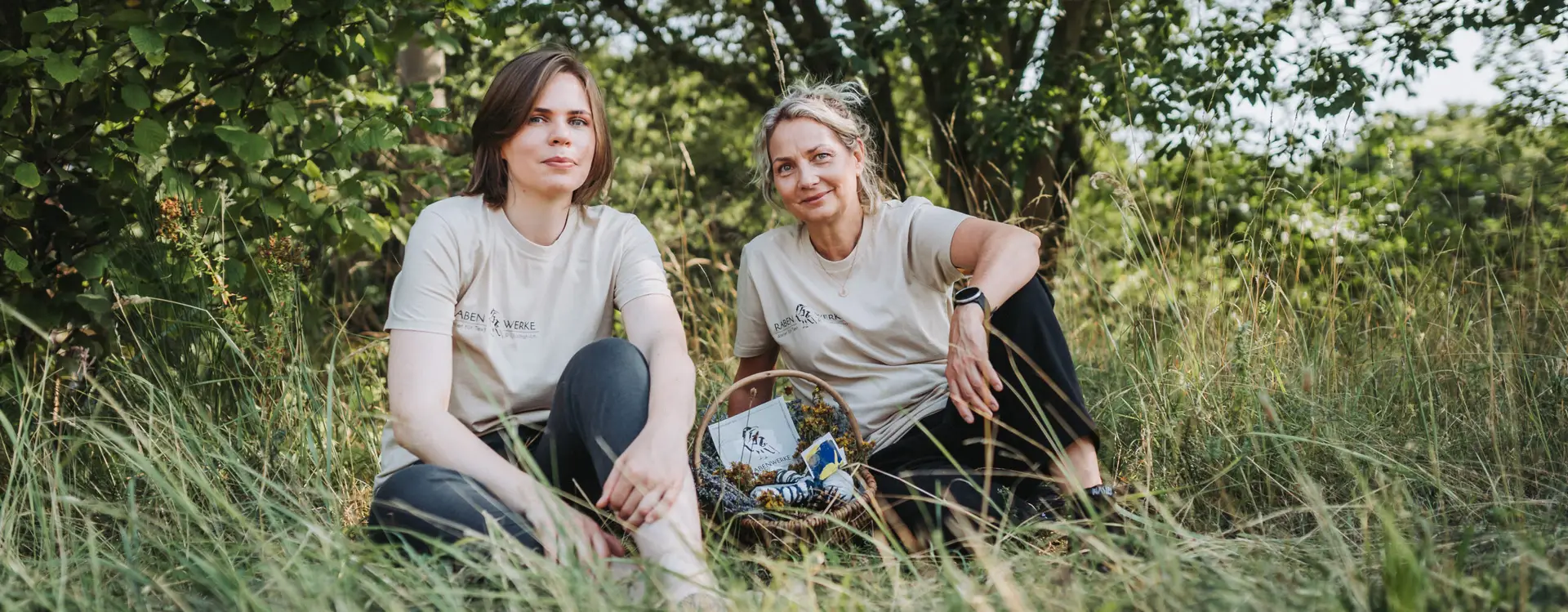 Zwei Frauen in nachhaltiger Kleidung sitzen in der Natur – authentische Imagefotografie für Unternehmen von Yourfilms.
