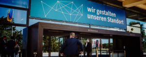 Teilnehmer betreten den Veranstaltungsort des Jahresempfangs der IHK zu Rostock 2025 unter dem Banner „Wir gestalten unseren Standort“