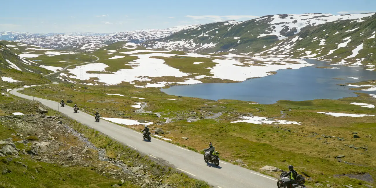 „Motorradreise Alpen – Panorama mit kurvenreicher Serpentinenstraße und schneebedeckten Gipfeln“