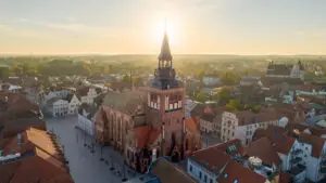 Drohnenaufnahme der Marienkirche in Güstrow bei tief stehender Sonne mit Blick über die historische Altstadt und das Güstrower Schloss