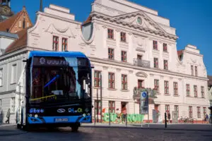Blau-schwarzer Wasserstoffbus von rebus Regionalbus Rostock vor dem historischen Rathaus in Güstrow, fotografiert für die Unternehmensfotografie.